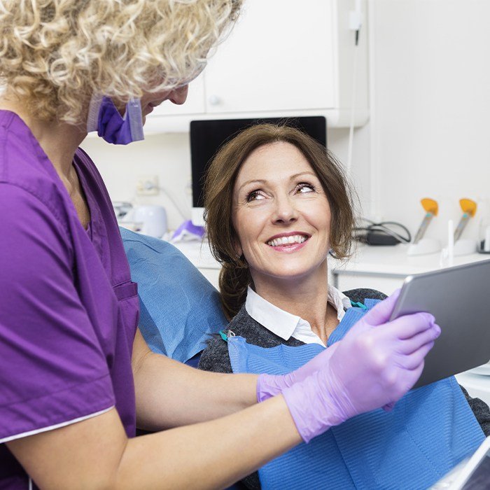 woman smiling up at dental assistant