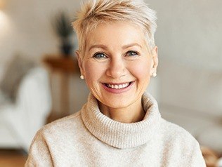 woman wearing tan sweater smiling at camera