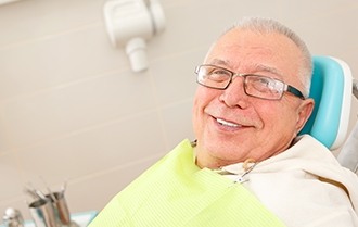 man with glasses laying back in exam chair