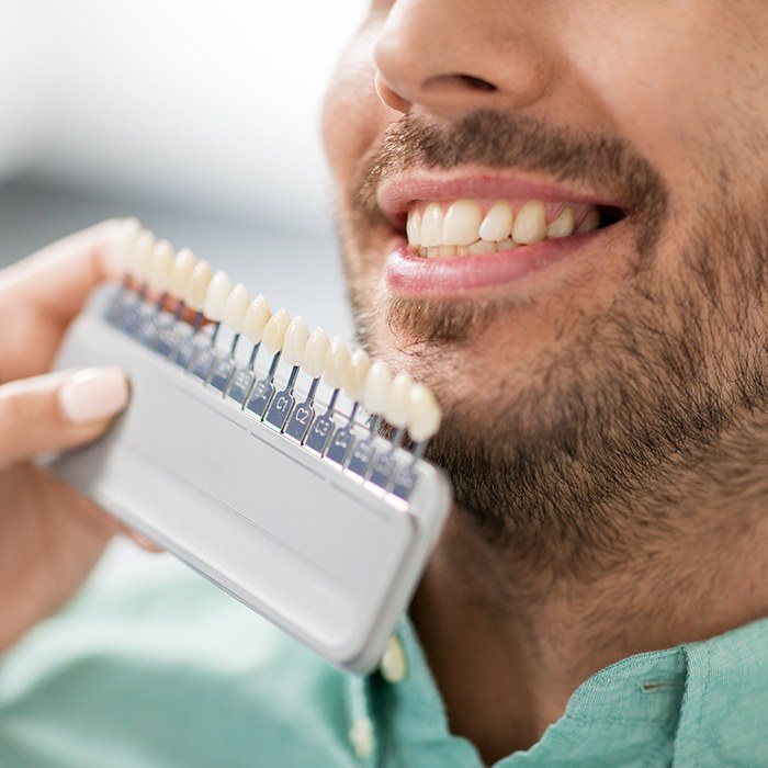 veneer chart in front of bearded man's smile