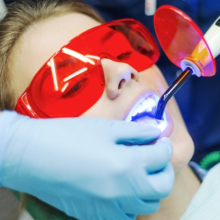 woman with red protective glasses getting cosmetic bonding