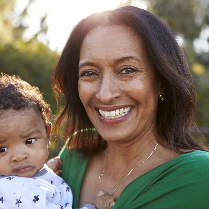 grandparent holding their grandchild and smiling