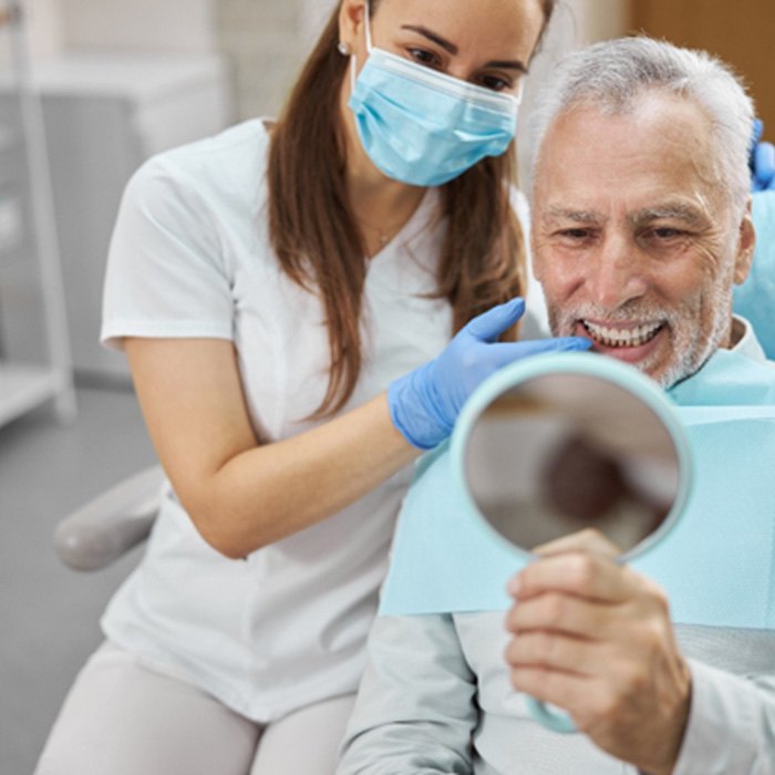 a dentist pointing to a patient’s mouth