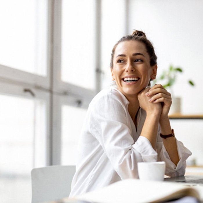 smiling person sitting at a desk