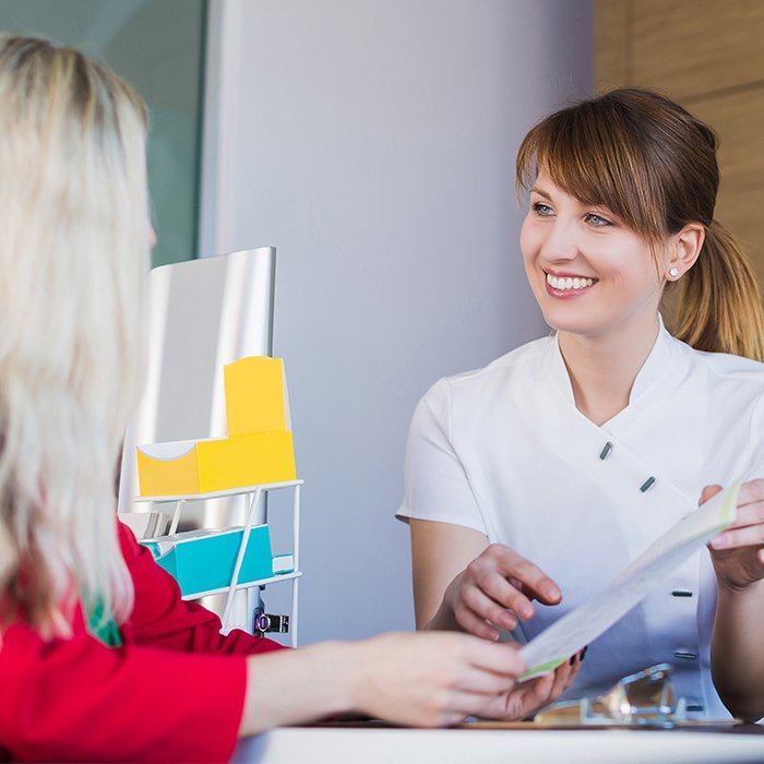 team member showing patient dental insurance paperwork