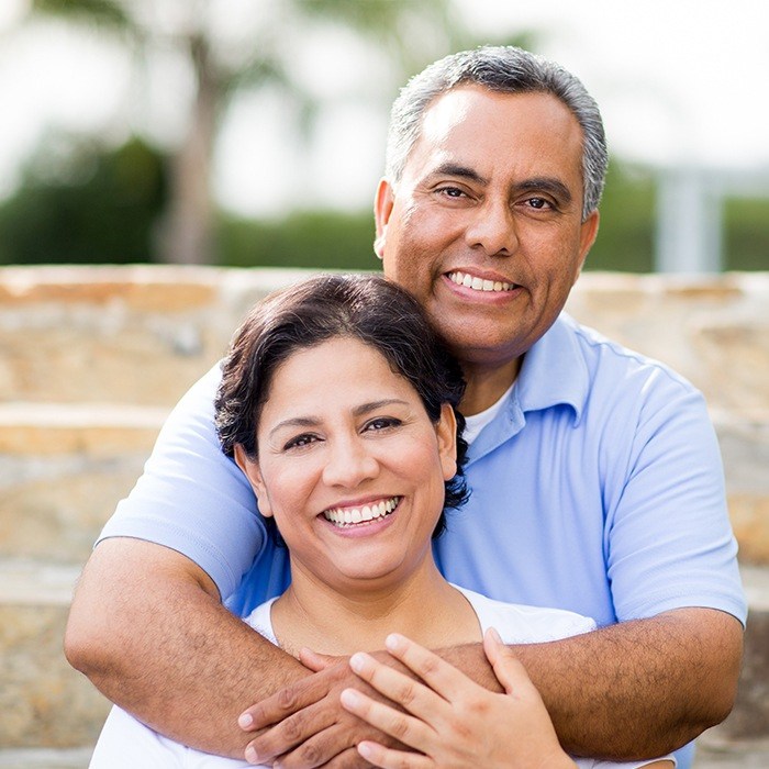 husband hugging arms around wife and smiling