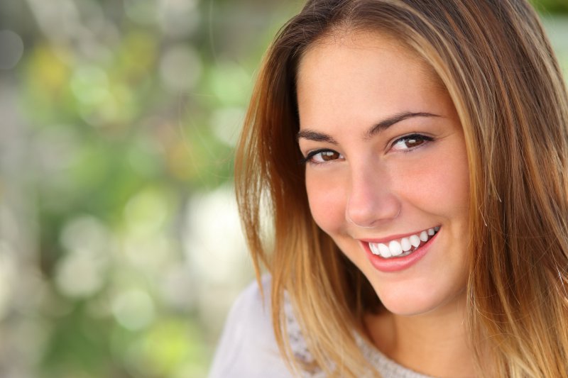 A woman smiling before visiting a dentist in Charlottesville.