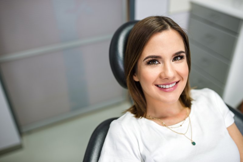 person with dental implants smiling at the dentist