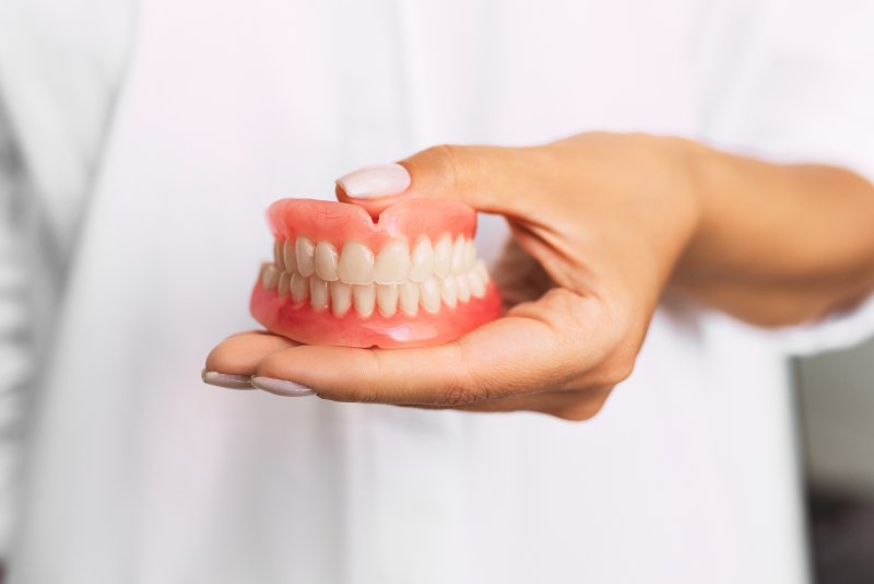 person holding dentures in Charlottesville