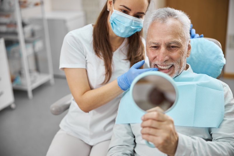 An older man happy with his new dental implants